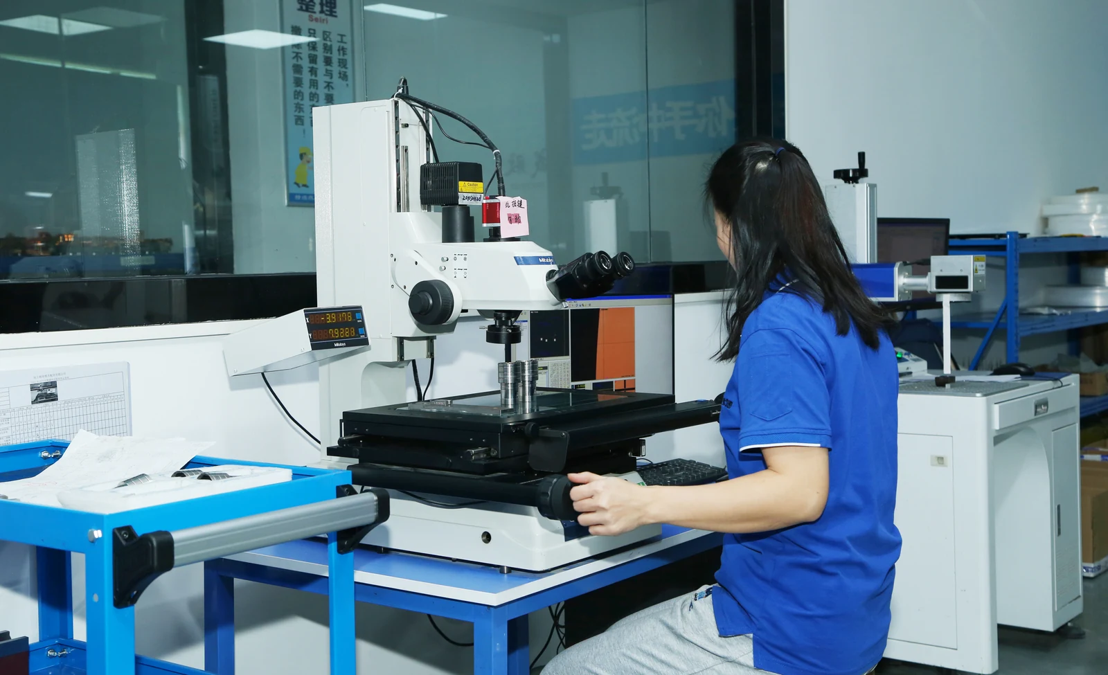 Technician using an optical measuring microscope to inspect a metal mold component