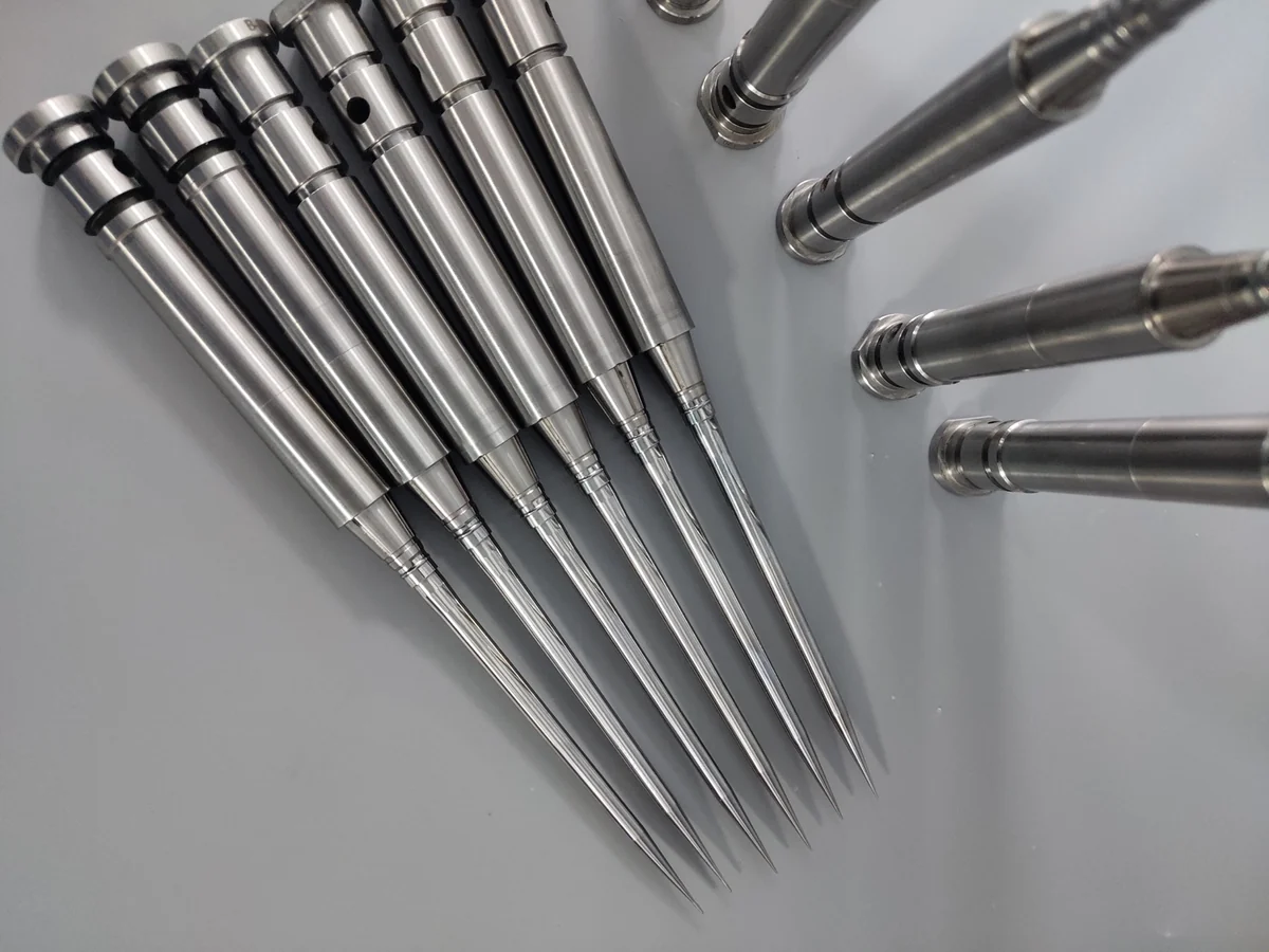 Close view of machined cylindrical pins with stepped features