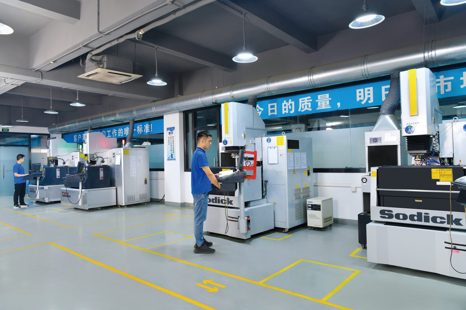 Operators beside Sodick EDM equipment in the workshop