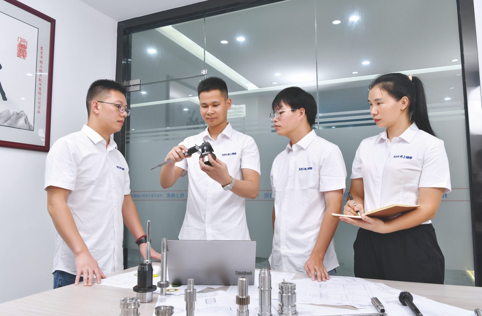 Team discussing a precision mold component