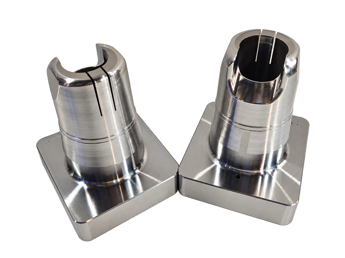 Background-removed display from source photograph: Two metal components with stepped cylindrical profiles, slots and square bases