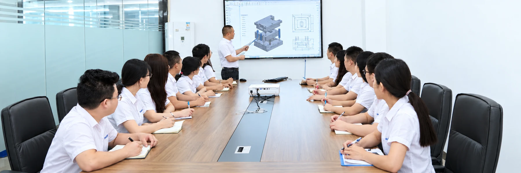 Colleagues discussing a mold design in a meeting