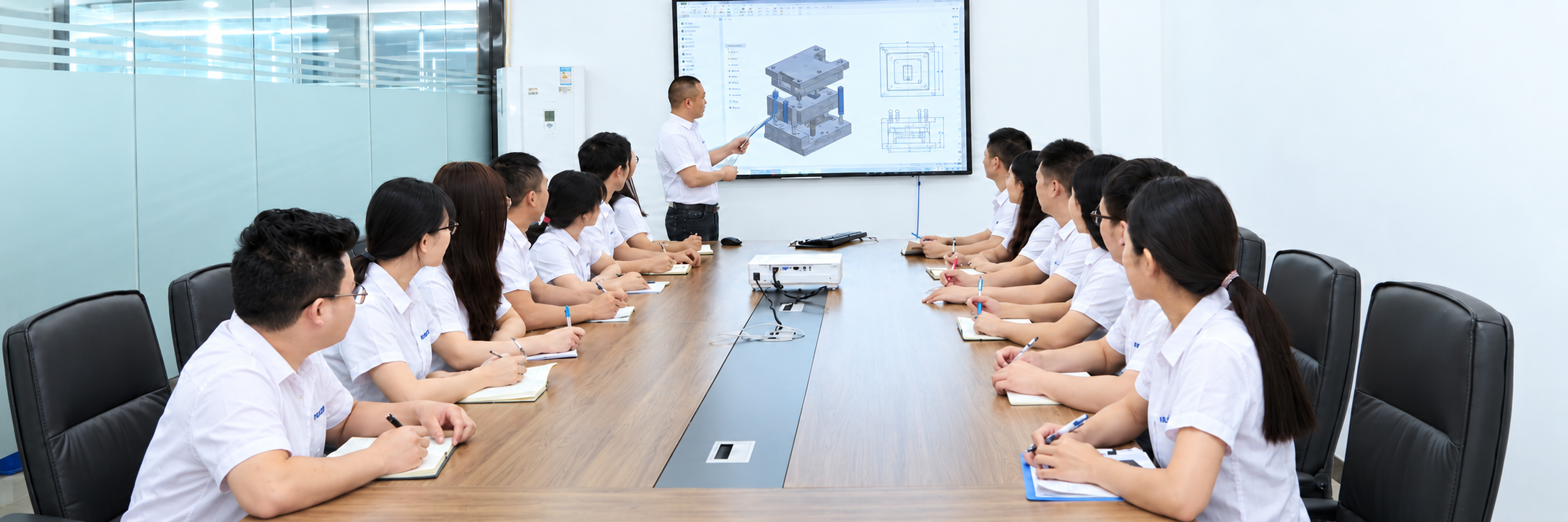 Meeting and training session with a presenter explaining a mold design on screen